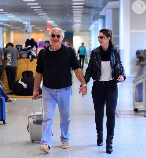 Antonio Fagundes e a namorada, Alexandra Martins, são flagrados sorridentes em aeroporto do Rio de Janeiro, onde são vistos com frequência, já que o ator mora em São Paulo e grava a novela 'Velho Chico' no Rio de Janeiro