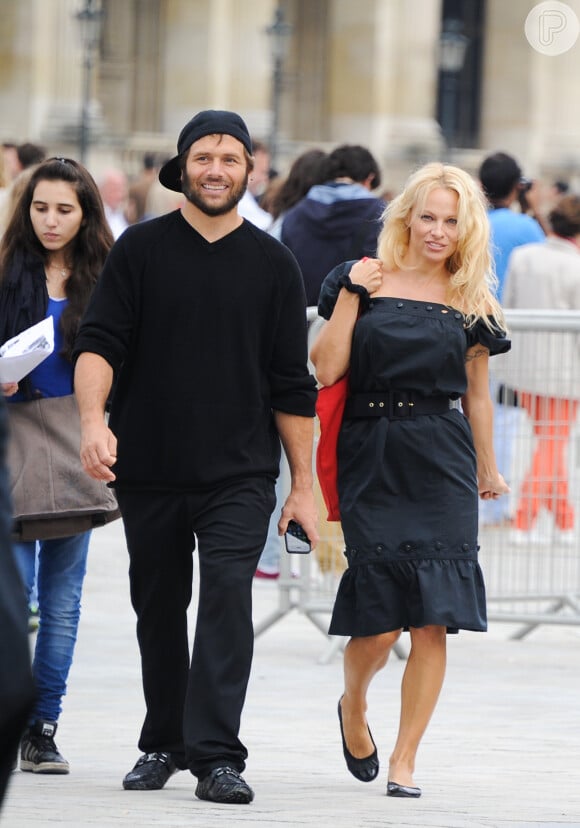 Pamela Anderson passeia com o ex-marido, Rick Salomon, em Paris. Na foto, ela exibe os cabelos longos e loiros