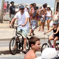 Marcelo Serrado anda de bicicleta na praia com a filha, Catarina