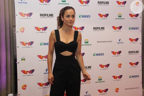 Alice Braga escolheu um macacão preto decotado para prestigar o primeiro dia do Festival do Rio