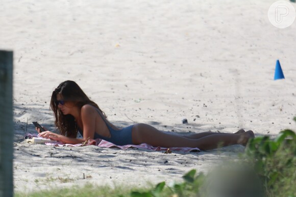 Enquanto Cauã malhava, a modelo relaxou lendo um livro na praia da Barra, Zona Oeste do Rio de Janeiro