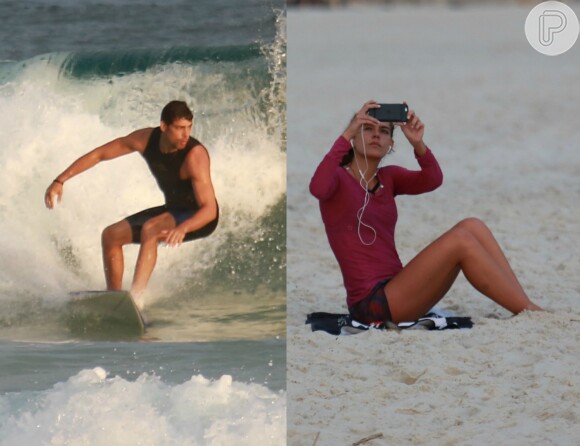 Enquanto Cauã Reymond surfa, Mariana Goldfarb se distrai mexendo no celular