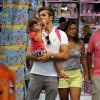 Otaviano Costa visita loja de brinquedos com a pequena Olívia no colo