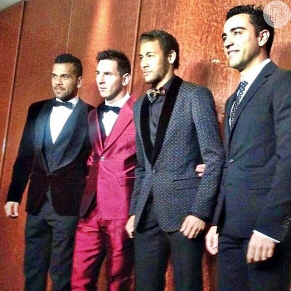 Daniel Alves, Messi, Neymar e Xavi posam para fotógrafos durante festa de premiação da FIFA. Vestindo um terno vermelho, o jogador Messi chamou atenção e foi um dos looks mais comentados do dia