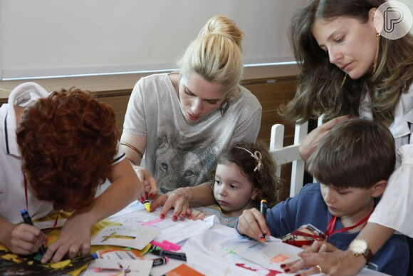 Leticia Spiller ajuda Stella a colorir um desenho durante um evento no Rio
