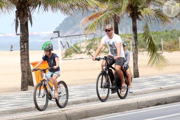 Rodrigo Hilbert e os gêmeos passeiam de bicicleta em orla da praia do Leblon, no Rio de Janeiro