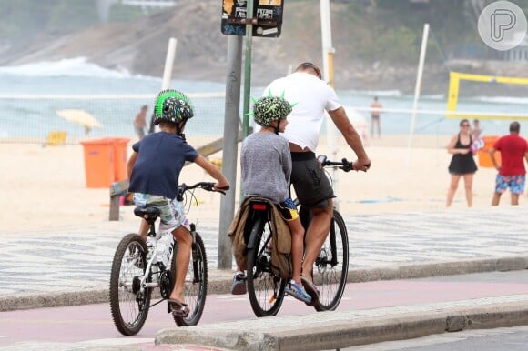 Rodrigo Hilbert e os filhos, Francisco e João, deixam a praia de bicicleta