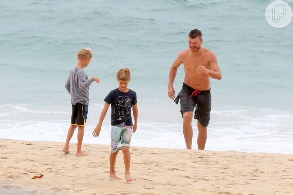 Rodrigo Hilbert corre na areia da praia do Leblon para alcançar os filhos