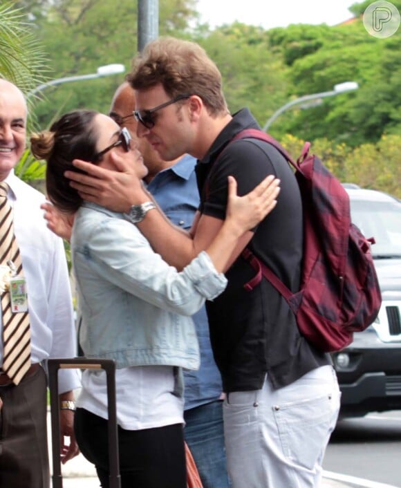 Fernanda Vasconcellos e Cássio Reis se beijam na entrada de aeroporto