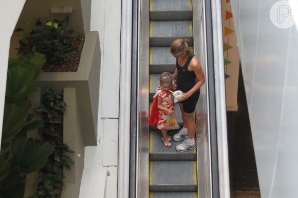 Luiza desde a escada rolante com a filha