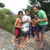 Jack Johnson posa com crianças durante visita à Prainha, na Zona Oeste do Rio de Janeiro