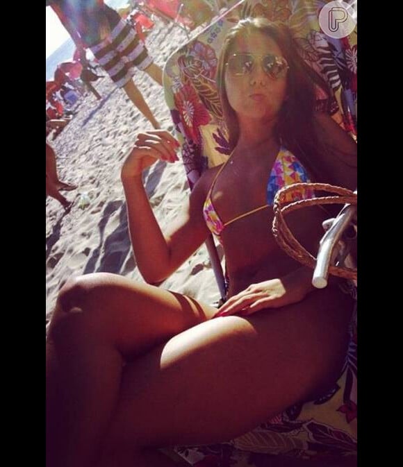 Carolina Portaluppi, de biquíni colorido bem pequeno, mostra o corpão na praia de Ipanema neste domingo