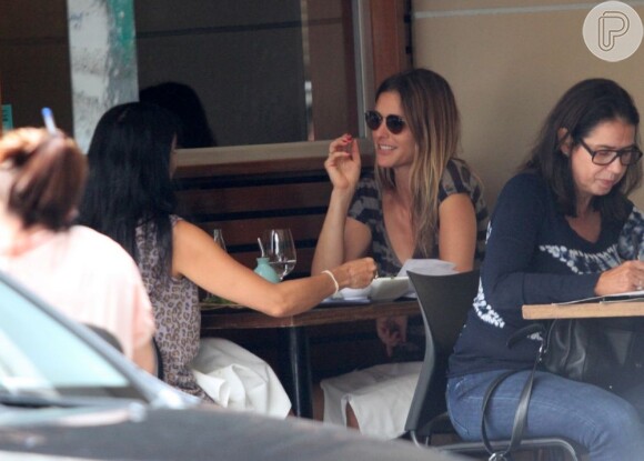 Fernanda Lima conversa com a amiga em restaurante da zona sul do Rio