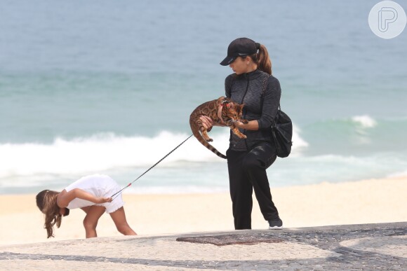 Grazi Massafera e Sofia não dispensaram a coleira para levarem Sol à praia do Rio de Janeiro