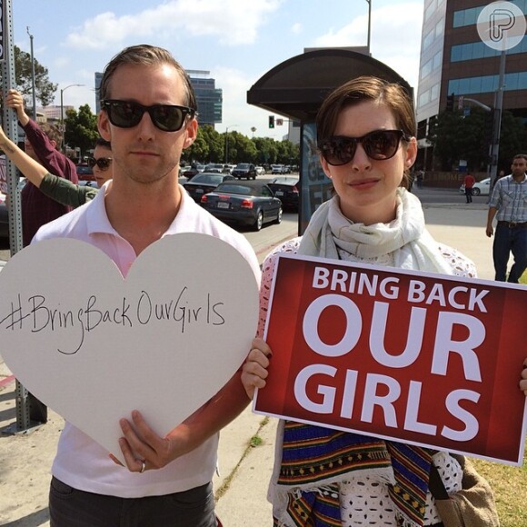 Anne Hathaway posa oa lado do marido durante protesto da campanha '#BringBackOurGirls'
