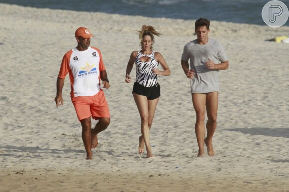 Danielle Winits coloca o namorado, Amaury Nunes, para malhar com ela na praia
