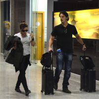 Cleo Pires tem malas carregadas pelo namorado, Rômulo Neto, em aeroporto do Rio