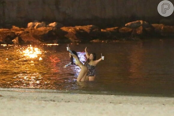 Rihanna se diverte em praia do Rio com assistente pessoal