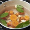 Em uma panela, coloque para cozinhar a cenoura, o gengibre picado, a cebola e o louro