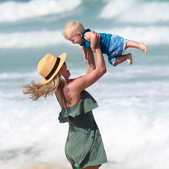 Karina Bacchi segura o filho, Enrico, no alto perto do mar da Barra da Tijuca