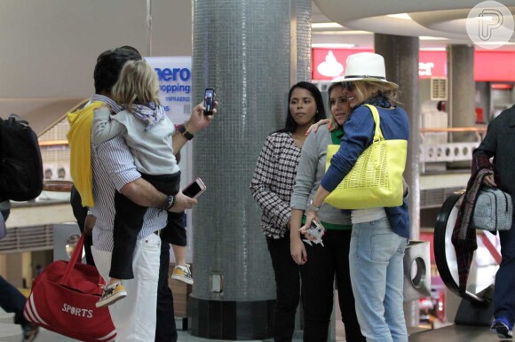 Adriane Galisteu posa para foto com fã no aeroporto