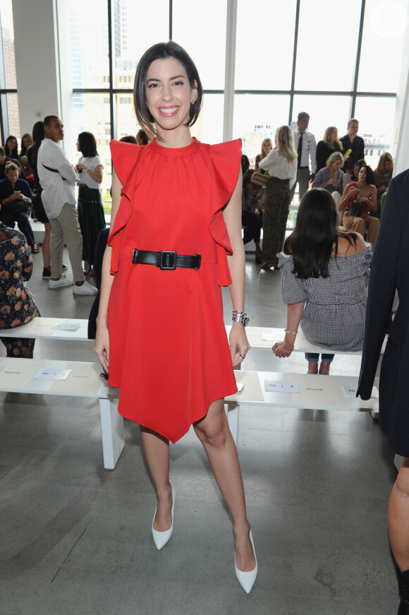 A blogueira Camila Coutinho escolheu um vestido vermelho com cinto preto para a Semana de Moda de Nova York