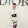 Para assistir ao desfile de Christian Dior, em Paris, a blogueira Camila Coelho apostou em um vestido longo branco rendado com o cinto largo preto da grife