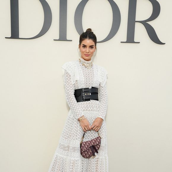 Para assistir ao desfile de Christian Dior, em Paris, a blogueira Camila Coelho apostou em um vestido longo branco rendado com o cinto largo preto da grife