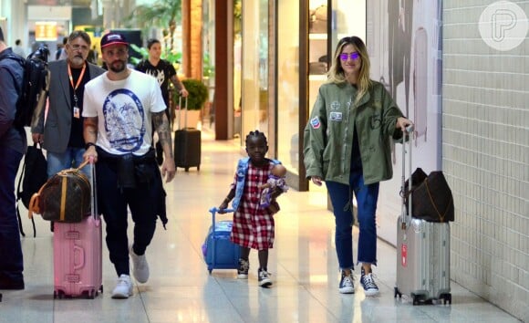 Para viagem em família, Giovanna Ewbank aposta em look decolado com jeans e All Star, enquanto Títi, sua filha, investe em vestido xadrez e sobreposição com colete jeans