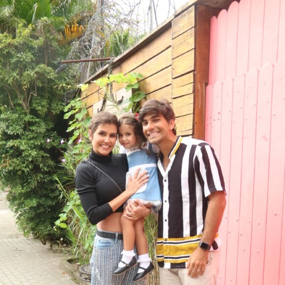 Deborah Secco posa sorridente com a filha e o marido para fotos
