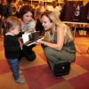 Eliana brinca com a filha da escritora Carolina Kotscho, Olga, em lançamento de livro