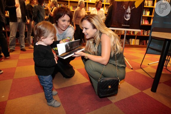 Eliana brinca com a filha da escritora Carolina Kotscho, Olga, em lançamento de livro