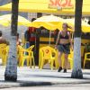 Adriana Esteves caminha de top e short em orla de praia de São Conrado