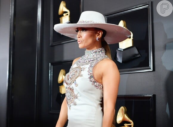 No Grammy Awards, Jennifer Lopez apostou em um chapéu glamouroso em off white, mesmo tom do vestido longo da grife Ralph & Russo