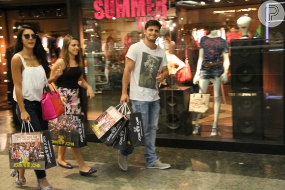 Com várias sacolas na mão, Bruno Gissoni faz compras com a namorada