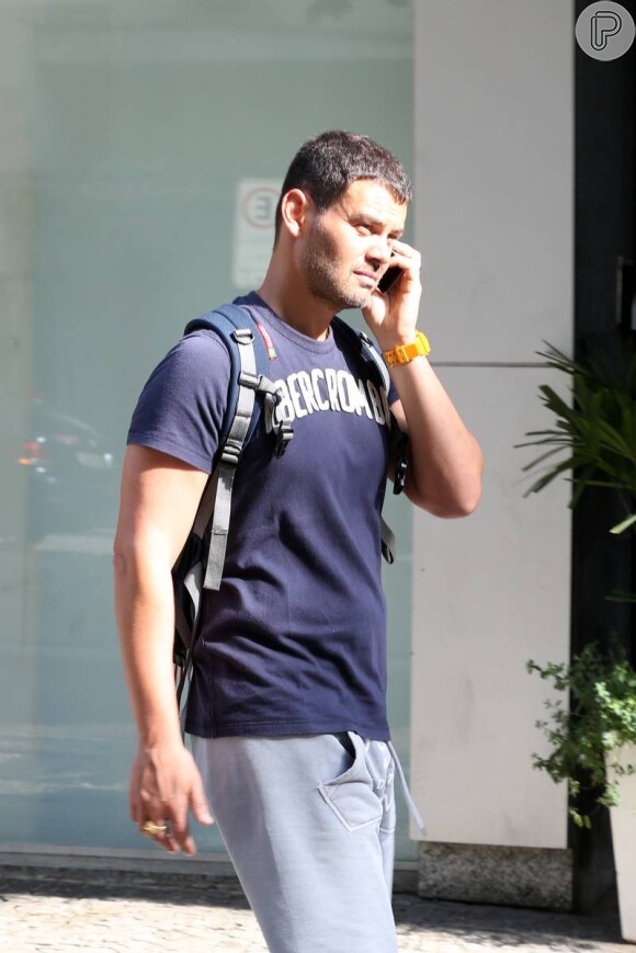 Com o corpo musculoso, Carmo Dalla Vecchia não larga o telefone enquanto caminha no Rio