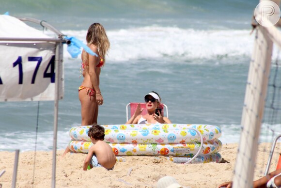 Leticia Birkheuer observa o filho, João Guilherme, brincando na areia da praia do Leblon, Zona Sul do Rio