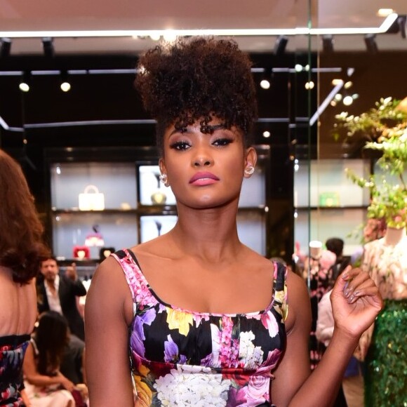 Erika Januza combinou o vestido floal com fundo preto com sapatos amarelos no look do evento da grife Dolce & Gabanna