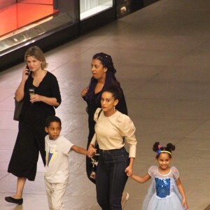 Taís Araujo caminhou de mãos dadas com os filhos, João Vicente e Maria Antonia, em shopping