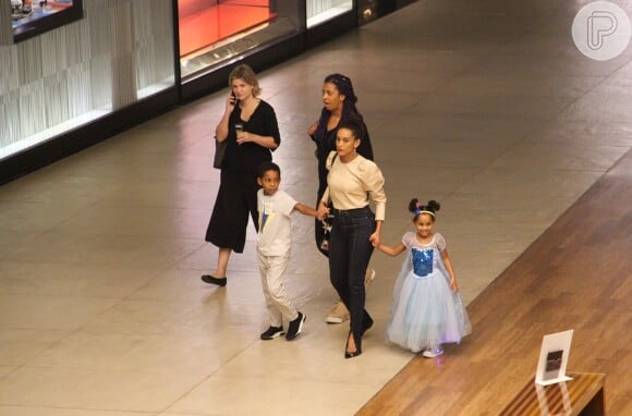 Taís Araujo caminhou de mãos dadas com os filhos, João Vicente e Maria Antonia, em shopping