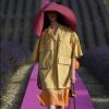 Desfile da Jacquemus na França: pegada utilitária no look com camisa em estilo safári e saia mídi. Olho no chapéu enorme!