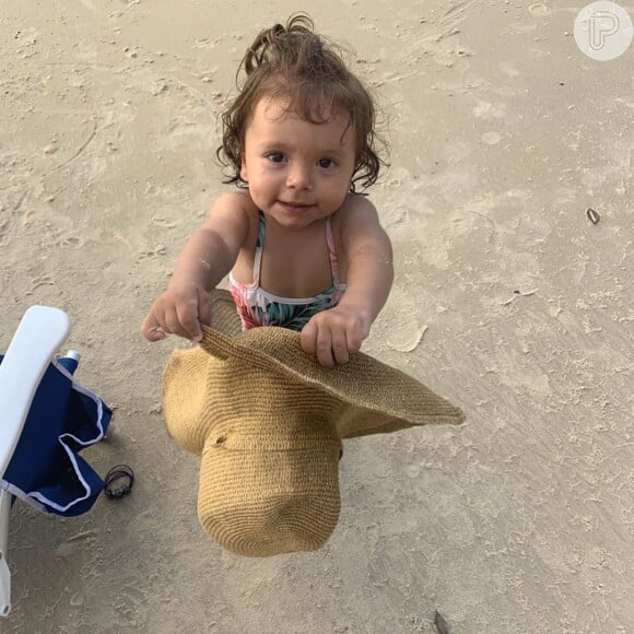 Patricia Abravanel mostra filha brincando com chapéu na praia nesta quinta-feira, dia 08 de agosto de 2019