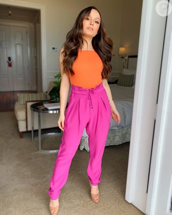 Larissa Manoela investe no segundo look blusa justa na cor laranja e calça jogging social rosa