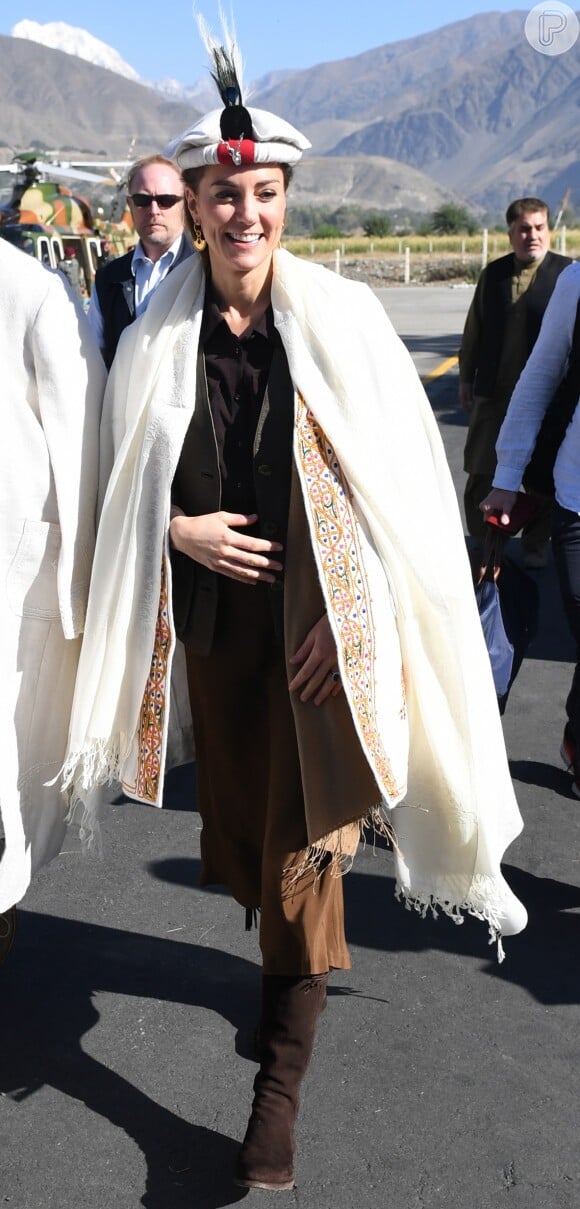 Kate Middleton usa um Chitrali Chugha, espécie de sobretudo, ao chegar à província