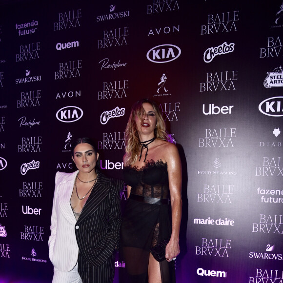 Cleo posa com Luciana Gimenez no tapete roxo do Baile da Bruxa