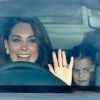 Kate Middleton acena para fotos ao chegar em almoço de família real no carro com os filhos