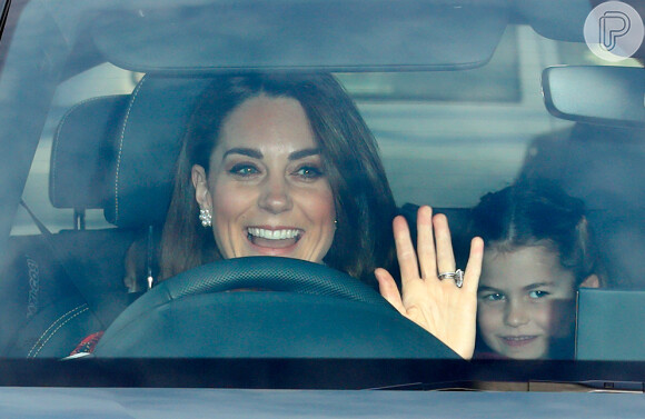 Kate Middleton acena para fotos ao chegar em almoço de família real no carro com os filhos