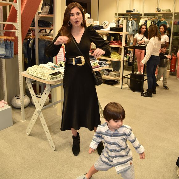 Bruna Hamú se diverte ao perceber as brincadeiras do filho diante dos fotógrafos