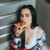 Cleo comendo uma fatia de pizza em foto postada no seu Instagram
