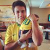 O marido de Luma Costa, Leonardo Martins, segura o filho, Antônio, em clima de Copa do Mundo